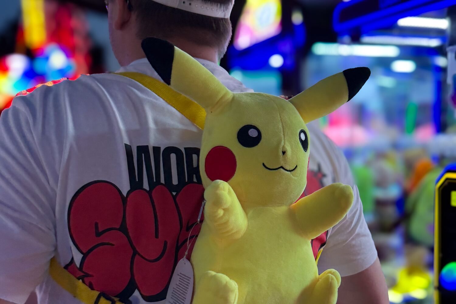 Duncan van achteren in een arcadehal, met een Pikachu-knuffel als rugzak