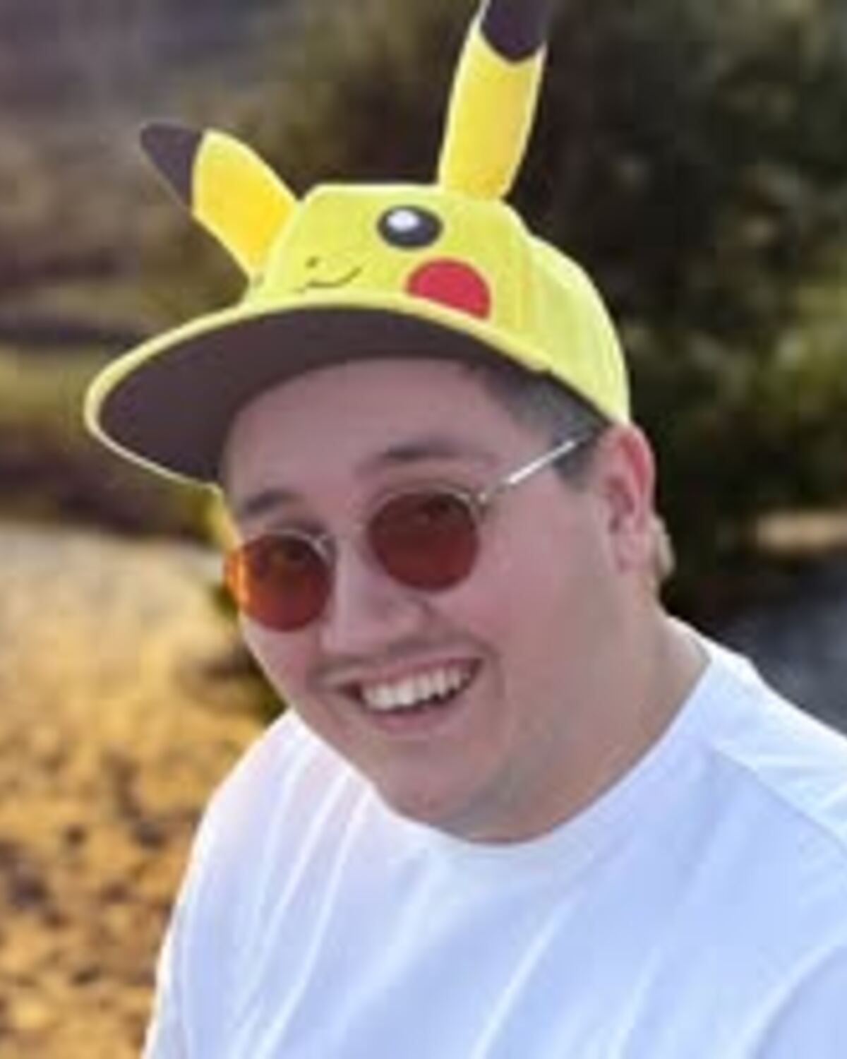 Duncan met Pikachu-pet en zonnebril, buiten in het najaar